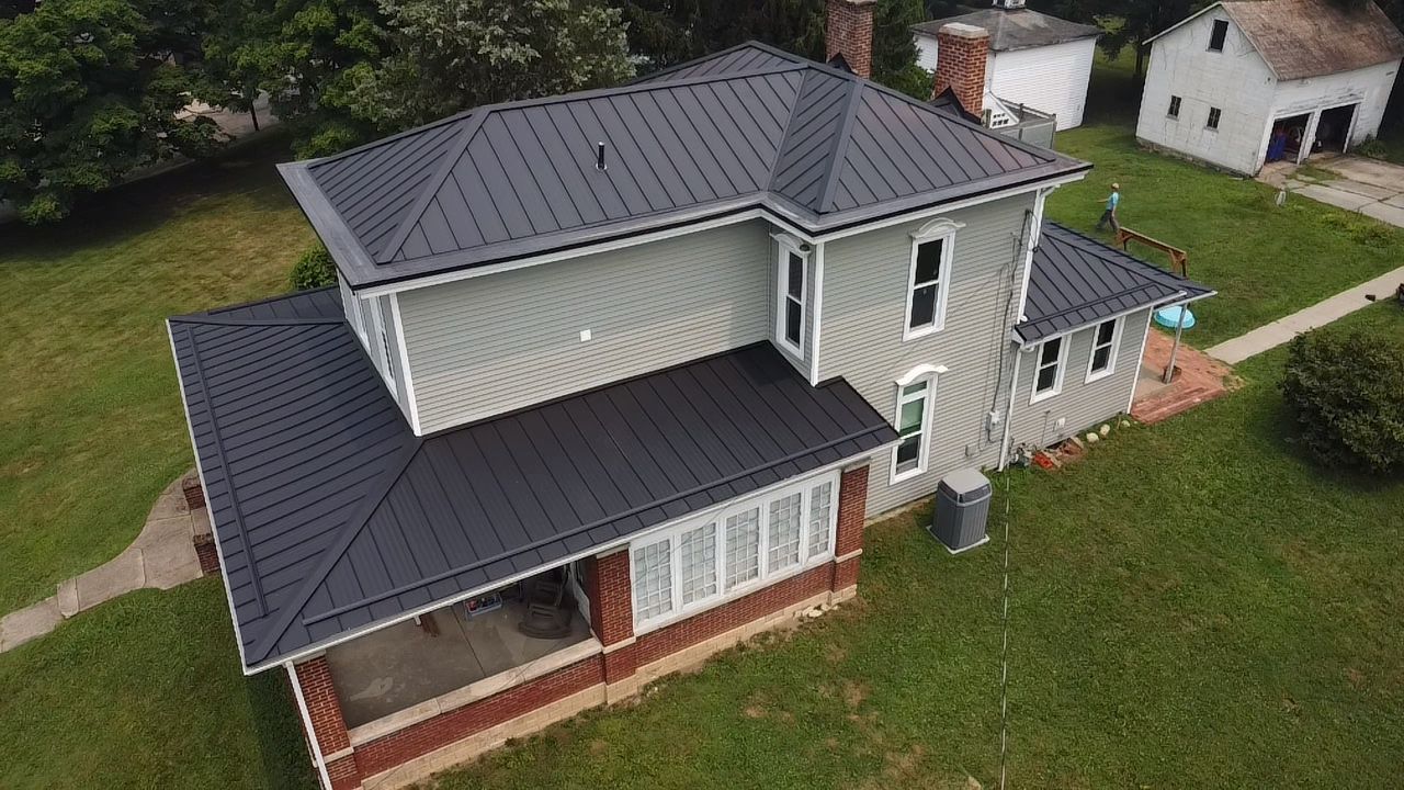Two-story home with new dark metal roof