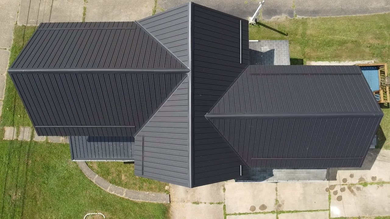 Complex metal roof with multiple gables, aerial view
